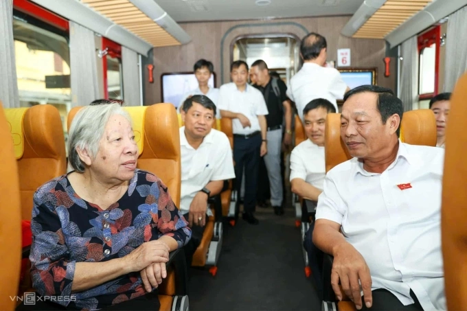 Ông Lê Văn Hiệu, Phó bí thư Thành ủy, Chủ tịch HĐND thành phố, trò chuyện cùng hành khách đi tàu khi kiểm tra thực tế cơ sở hạ tầng chuẩn bị cho việc đưa đón cán bộ, công chức bằng tàu hỏa. Ảnh: Lê Tân