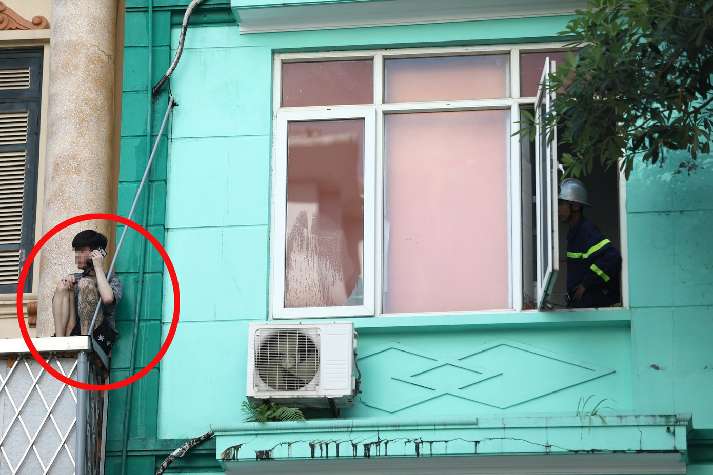 Nam thanh niên nghi 'ngáo đá' ngồi vắt vẻo ở lan can tầng 2 ngôi nhà- Ảnh 1.